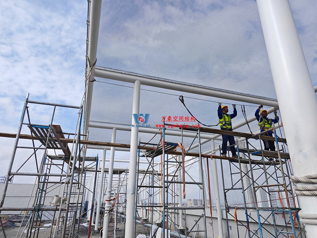 聚焦工程高質量建設，這個網格織物幕墻正在施工安裝中